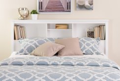 White bed with a shelf at the head