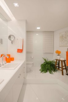 White split-level bathroom with orange accents