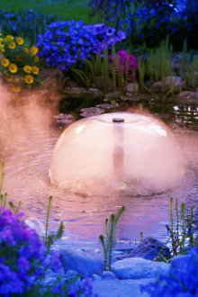 Осветен фонтан с мъгла