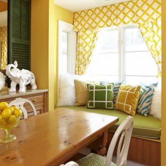 Cozy niche in the dining room with yellow walls and curtains.