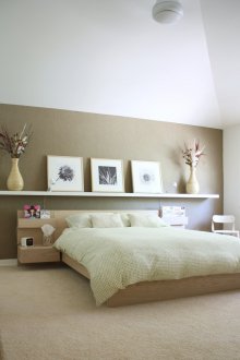 Снимки в дървена рамка над леглото в спалнята