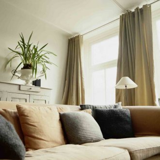 Gray-green curtains on the grommets in the apartment