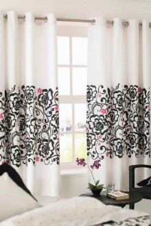 White curtains on grommets with black and pink print