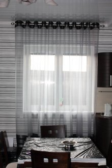 Transparent gray curtains on the grommets in the kitchen
