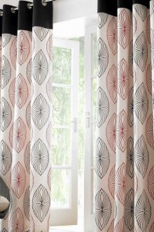 Black and white curtains on grommets with red and black print