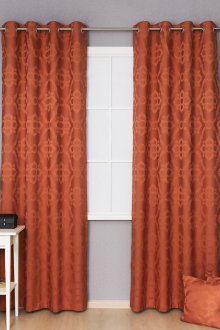 Orange curtains on grommets with a pattern