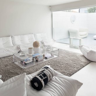 Сив пухкав килим в светлия интериор на хола