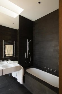 Черни каменни плочки в бяла вана