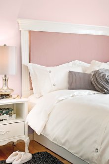 Katil dengan kepala katil berwarna merah jambu lembut