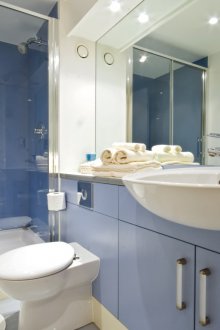 Bilik mandi biru dengan pancuran mandian