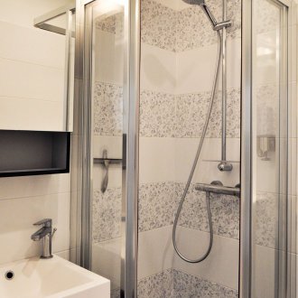 Bilik mandi bercorak dengan pancuran dan jubin