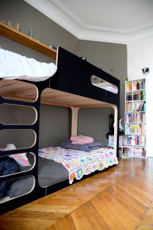 Kindergarten für drei Kinder mit einem schwarzen Bett