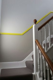 Дизайн на коридор със стълбище и жълта рамка.