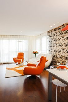 Дневна-трапезария с оранжеви и кафяви акценти в интериора