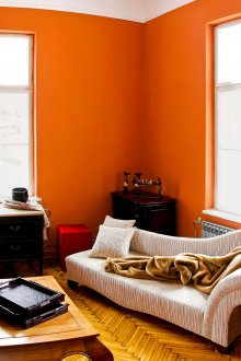 Оранжеви, кремави и черни цветове в хола