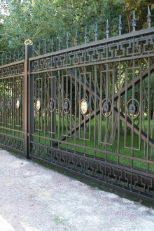 Черна кована ограда със златни акценти