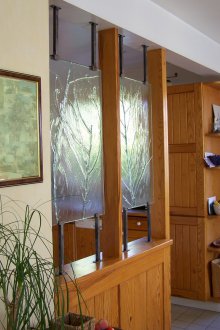 Преградата между кухнята и хола е от масивно дърво със стъкло