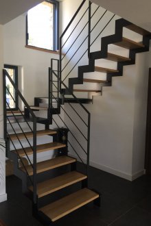 Стълбище към втория етаж в къщата върху черна метална рамка