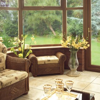 Кафяви плетени мебели на остъклена веранда