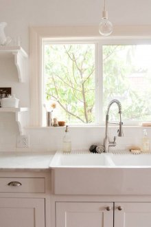 Бяла двойна мивка до прозореца в кухнята