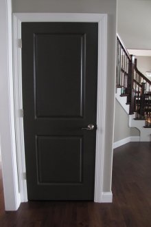 Черна врата и тъмнокафяв ламинат в стаята