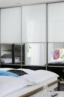 Голям ъглов гардероб с вграден телевизор в спалнята