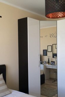 Черно-бял ъглов гардероб с огледало в спалнята