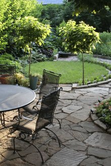 Метални мебели, дървета и цветя в дизайна на двора