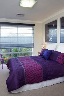 Лилаво спално бельо в бяла спалня