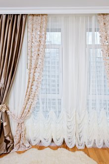 Тюл с бродерии и сатенени завеси в интериора на спалнята