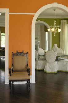 Бели корнизи върху оранжевата стена в коридора