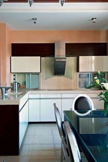 Прасковени стени в интериора на кухнята с бар за закуска и маса за хранене